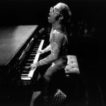 Elton John en una actuación al piano durante su carrera, inspiración para Rocket Man