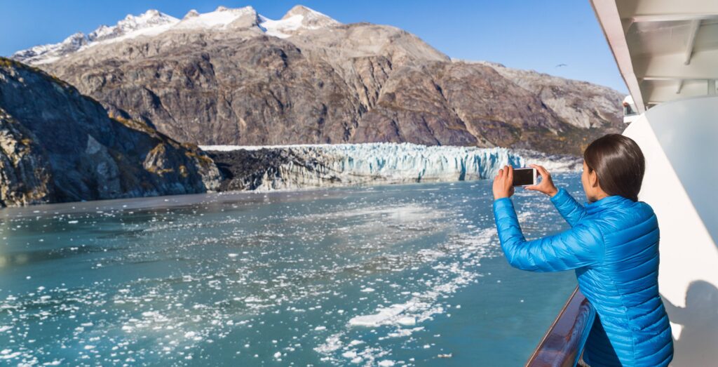 Pasajera fotografiando un glaciar en Alaska desde un crucero de Oceania Cruises