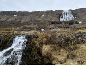 Cascada en Islandia en paisaje rocoso y vegetación baja