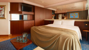 Suite del Costa Serena con cama doble, armarios de madera y luz cálida.