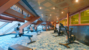 Gimnasio del Costa Serena con máquinas de cardio y ventanales panorámicos.
