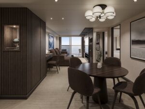 Suite de EXPLORA III con salón, comedor y acceso a terraza privada con vistas al océano.