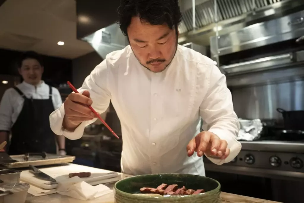 El chef Makoto Okuwa preparando con precisión platos de sushi Edomae en la cocina del Diamond Princess.