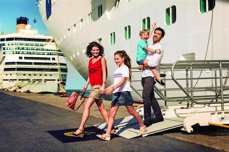 Una familia descendiendo de un barco de Costa Cruceros durante una escala en puerto mediterráneo