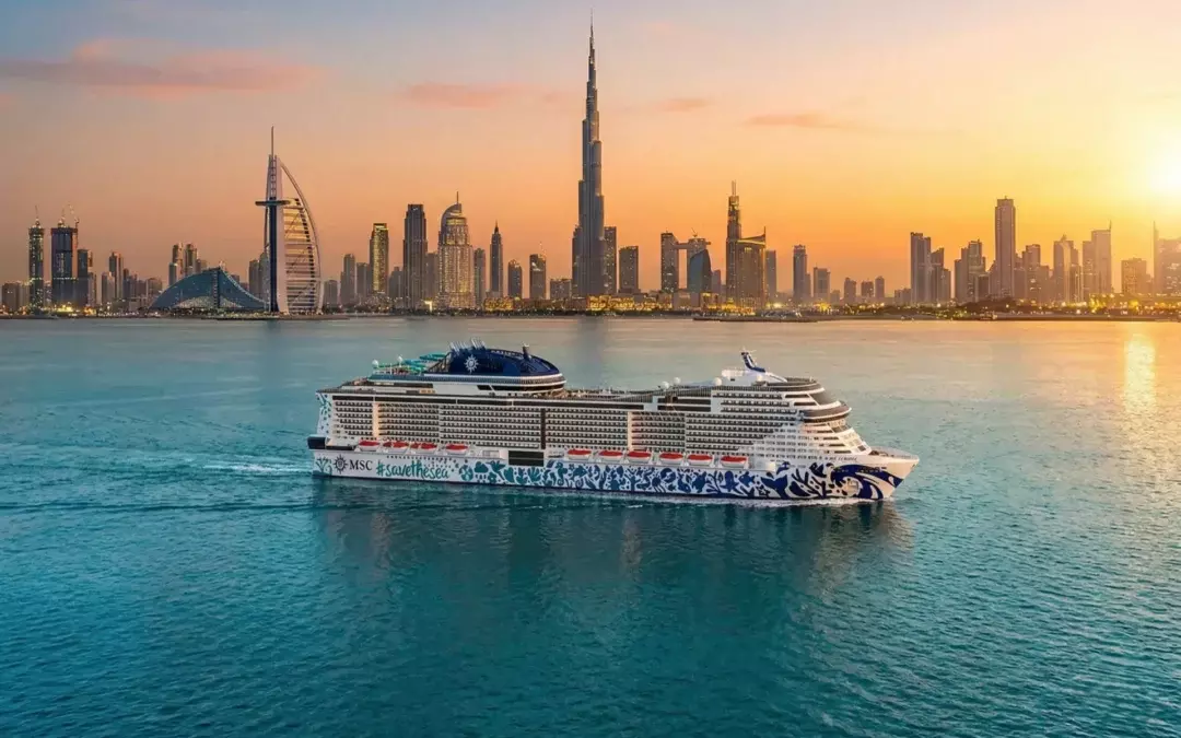 Crucero MSC Euribia con librea #savethesea navegando frente al horizonte de Dubái con el Burj Khalifa y el Burj Al Arab al atardecer
