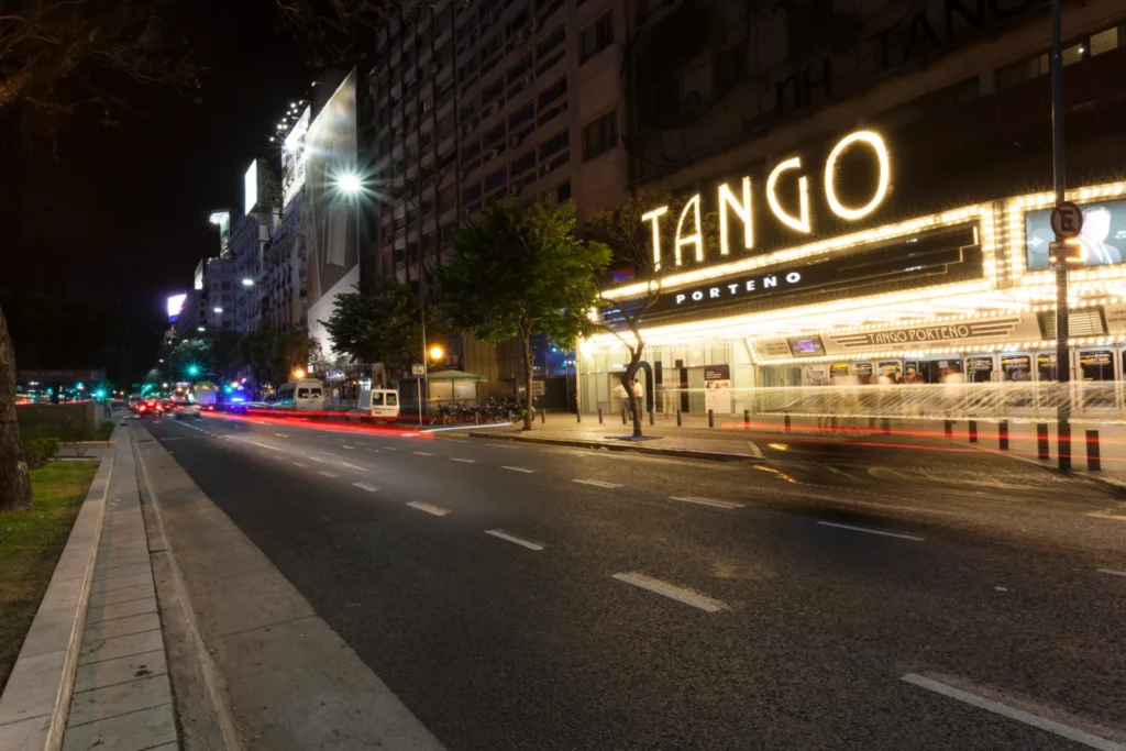 Vista nocturna de la Avenida Corrientes con las luces del teatro Tango Porteño