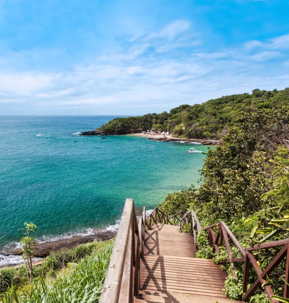 Escaleras de madera con vistas a una cala de aguas turquesas en la costa de Brasil