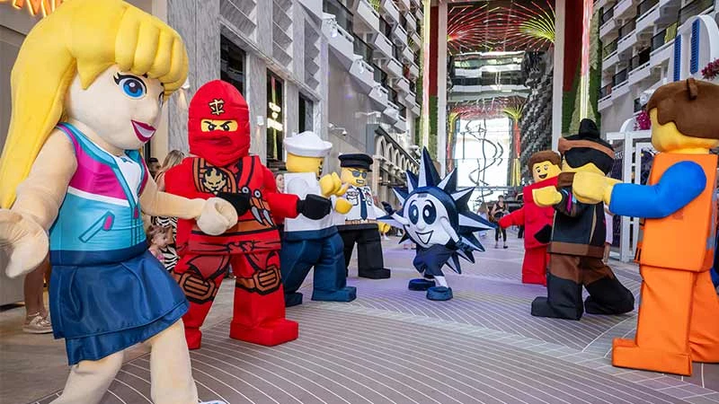 Personajes de LEGO y Ninjago interactuando con pasajeros en el paseo interior del crucero MSC World America.