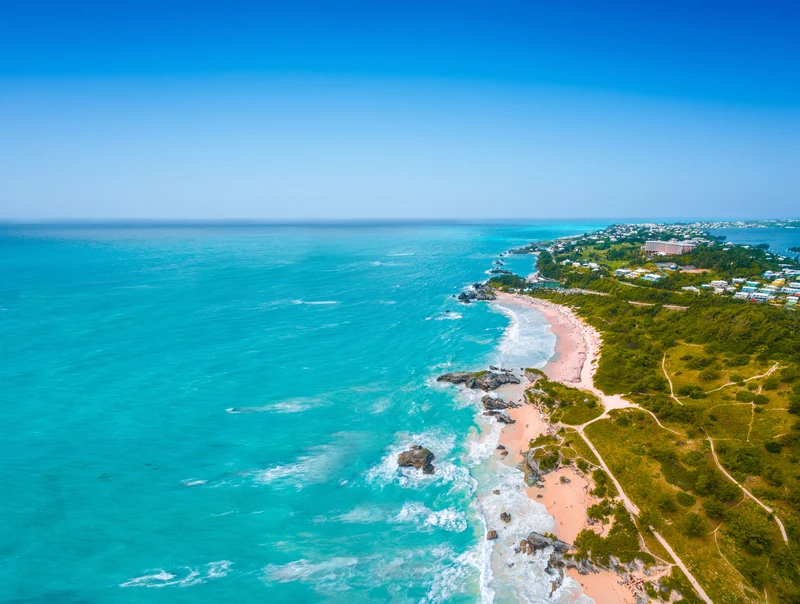 Costa de Bermudas con aguas turquesas, rocas rosadas y vegetación tropical, destino principal de los cruceros del Norwegian Jewel desde Filadelfia en verano de 2026