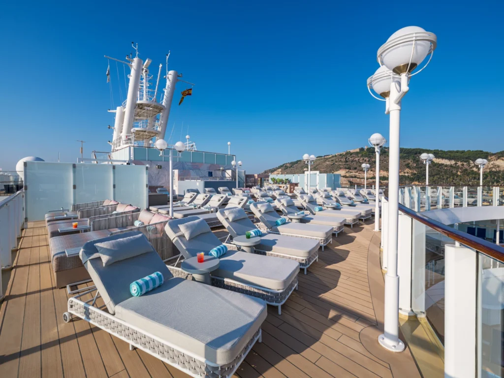 Vibe Beach Club del Norwegian Jewel, zona exterior exclusiva para adultos con tumbonas, sombras y vistas panorámicas al mar