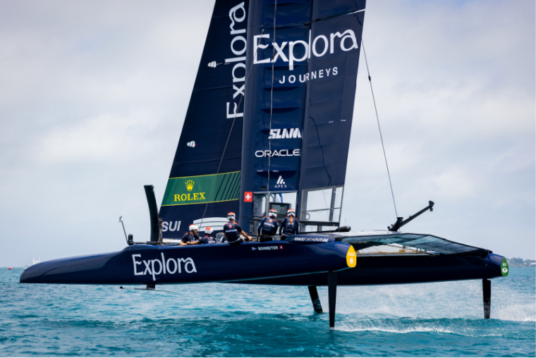 catamaran de competicion con el patrocinio de explora journeys navegando a gran velocidad en la americas cup