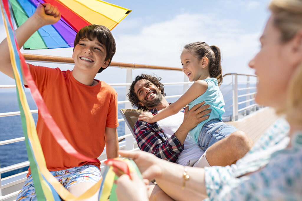 Familia jugando con una cometa en la cubierta exterior de un crucero