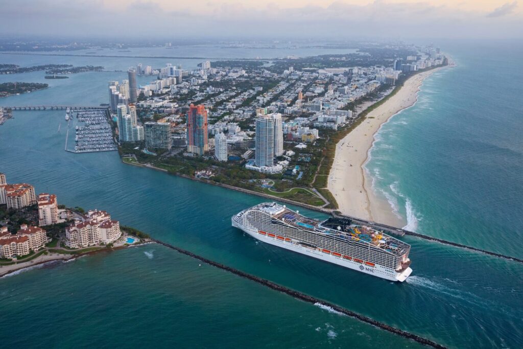 El crucero MSC World America navegando por el canal frente a la costa y los rascacielos de Miami Beach.