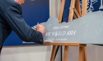 Ejecutivo firmando una placa de metal con el nombre MSC World Asia durante su ceremonia de corte de acero.