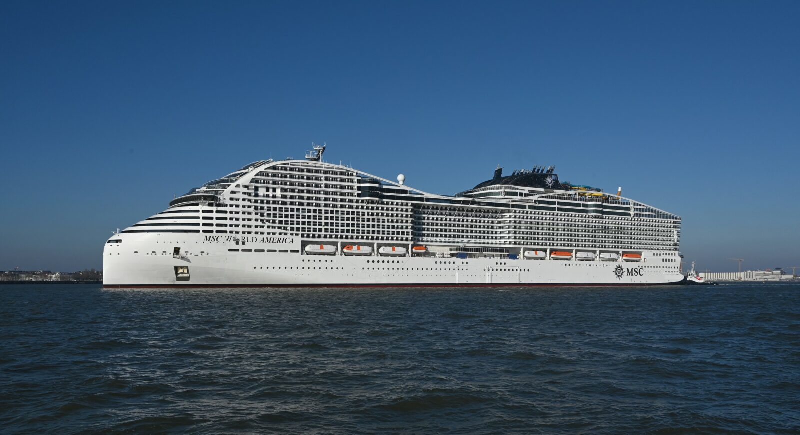 El crucero MSC World America navegando en el mar bajo un cielo azul despejado.