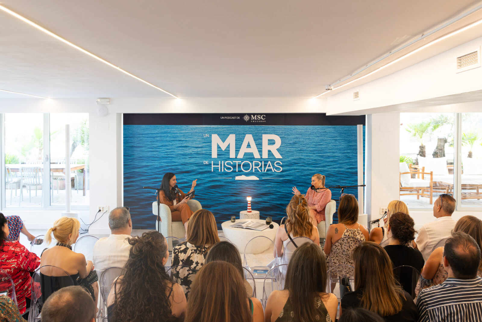 Dos mujeres conversan en un escenario frente a una audiencia durante la grabación del podcast Un Mar de Historias de MSC.
