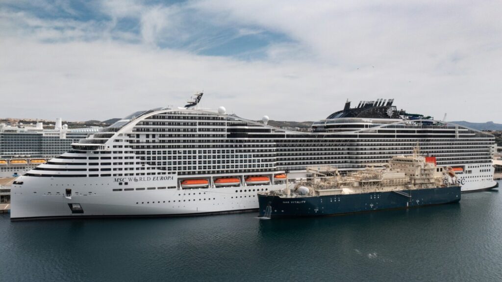 El crucero MSC World Europa recibiendo gas natural licuado del buque de suministro Gas Vitality en puerto.