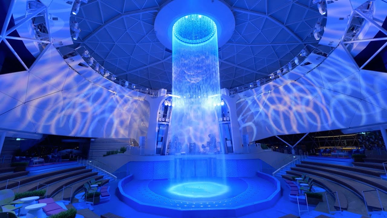 Espectacular cascada circular de iluminación azul en el AquaDome del crucero Icon of the Seas de Royal Caribbean.