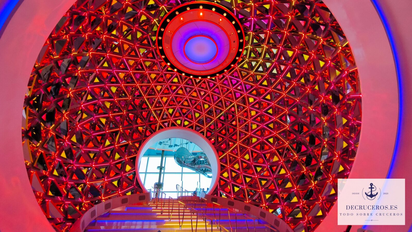 Estructura de cúpula geodésica con iluminación LED roja y amarilla en el interior del crucero Icon of the Seas.