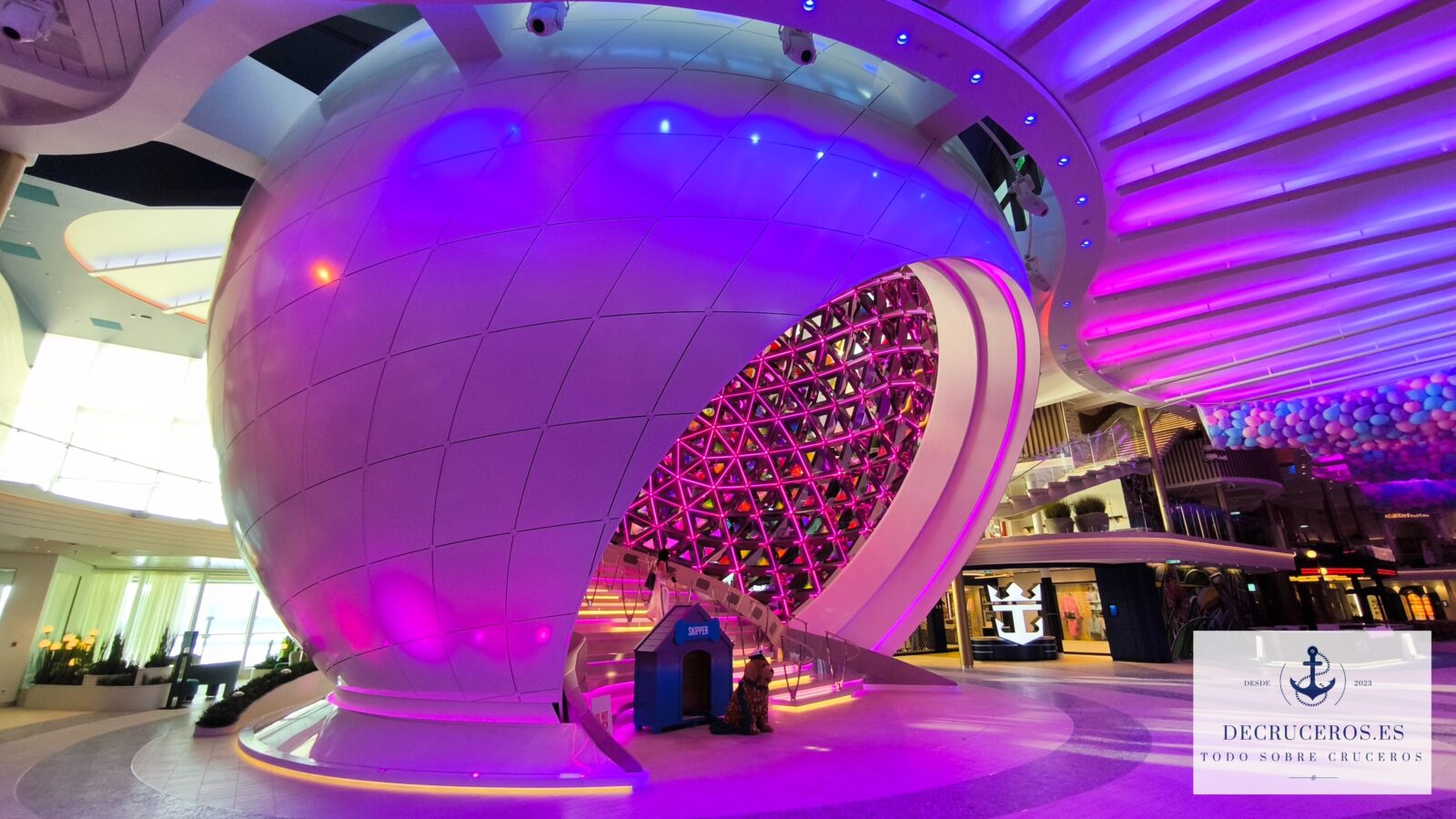 Estructura esférica iluminada con neones púrpuras en el interior del crucero Icon of the Seas