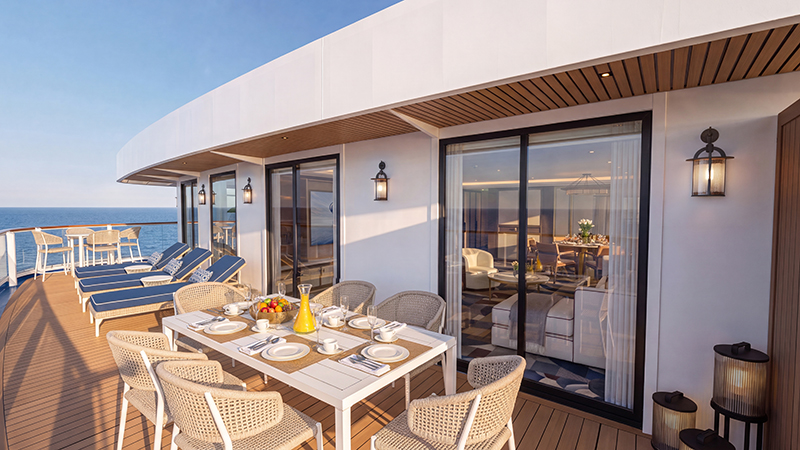Terraza de una suite de crucero con mesa de comedor, tumbonas y vistas al mar