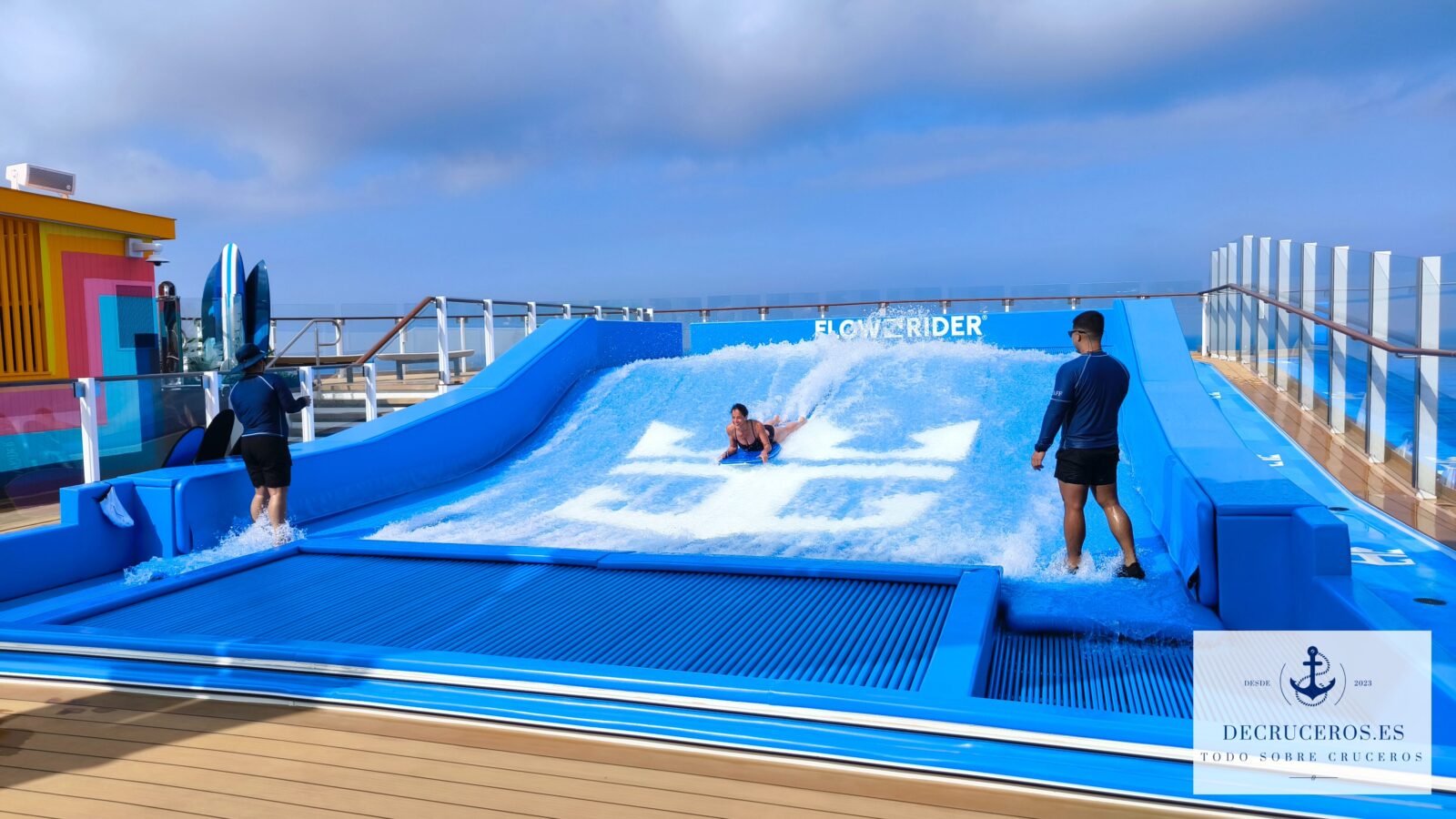 Una persona practicando bodyboard en el simulador FlowRider de un crucero Royal Caribbean bajo un cielo despejado.